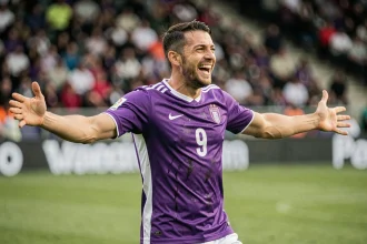 Joueur de football de Bergerac célébrant un but sur le terrain, meilleur buteur du classement